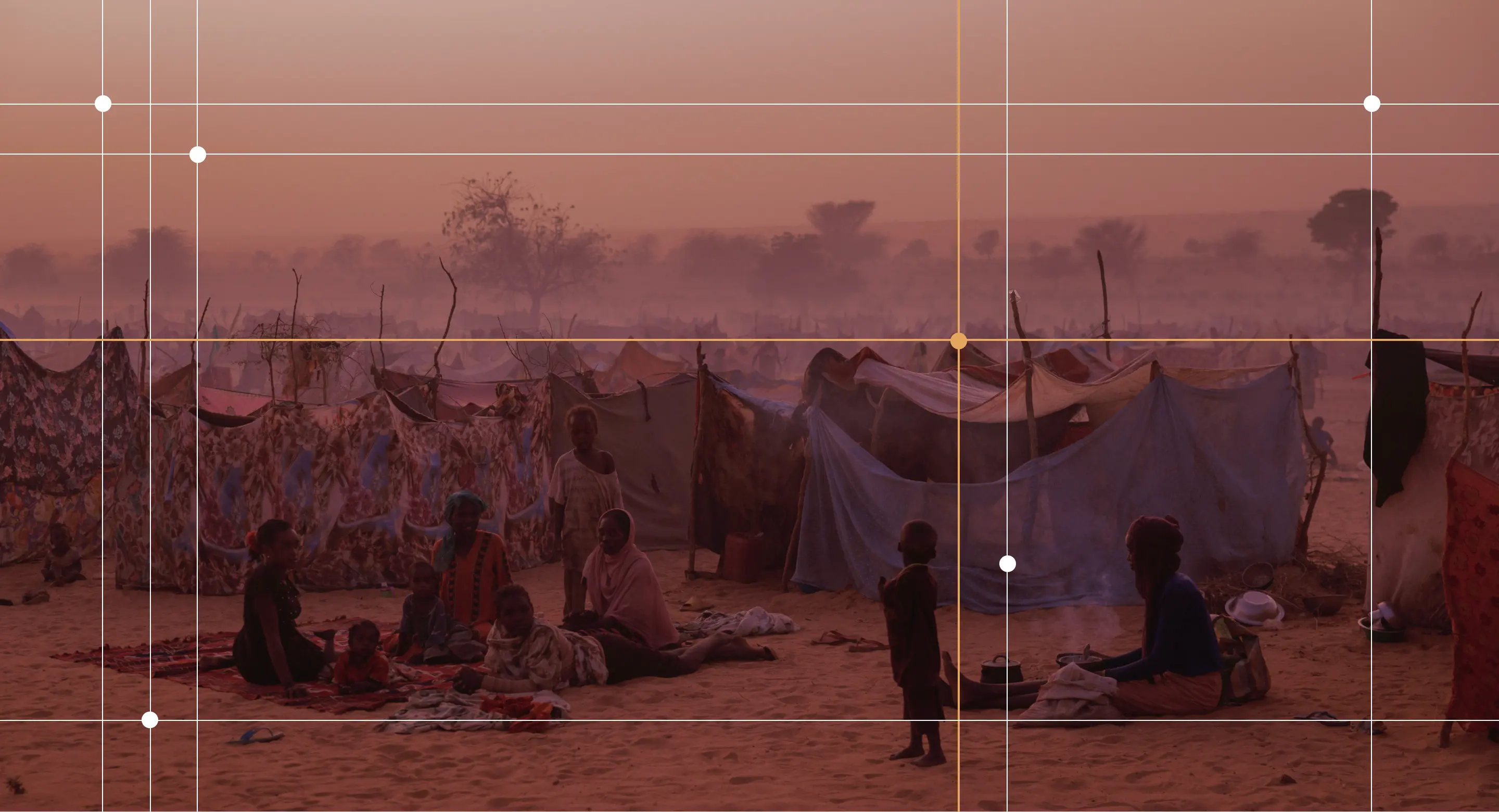 Newly arrived Sudanese refugees sit outside their makeshift shelters at twilight close to a relocation camp near Adre, Chad